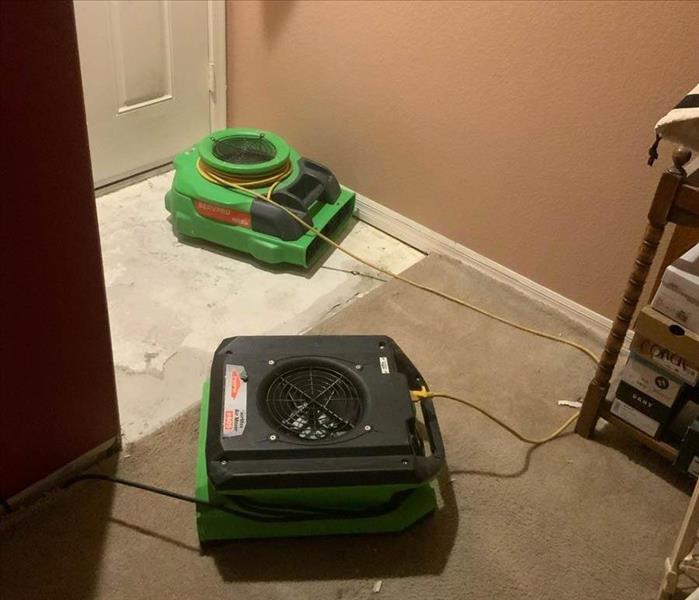 Green air movers on the ground indoors. 