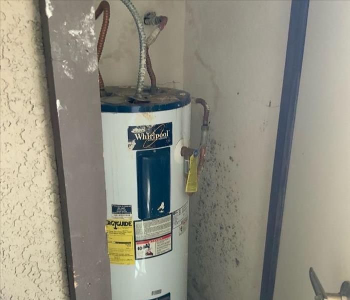 Water heater in a room with concrete floors.